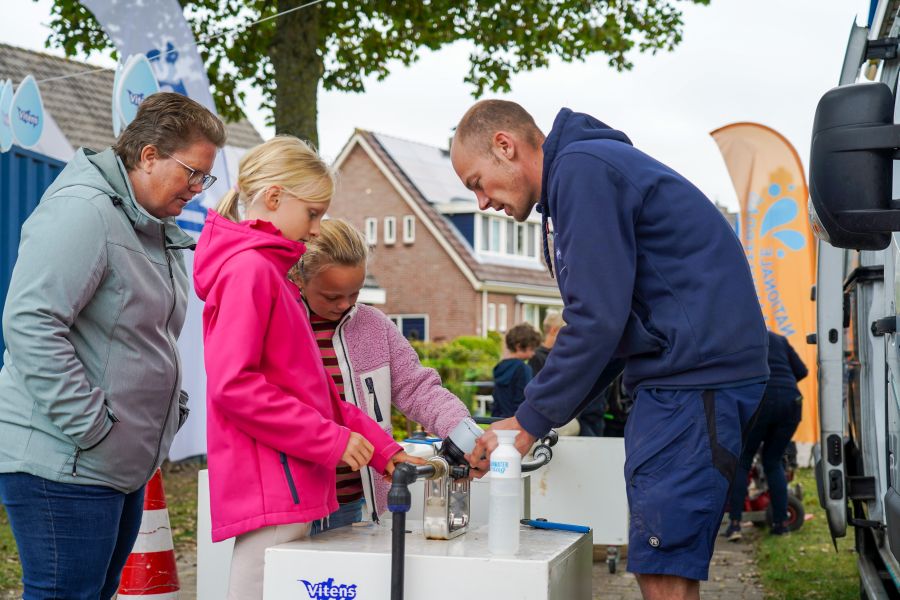 Monteur en kinderen die kijken naar een watermeter