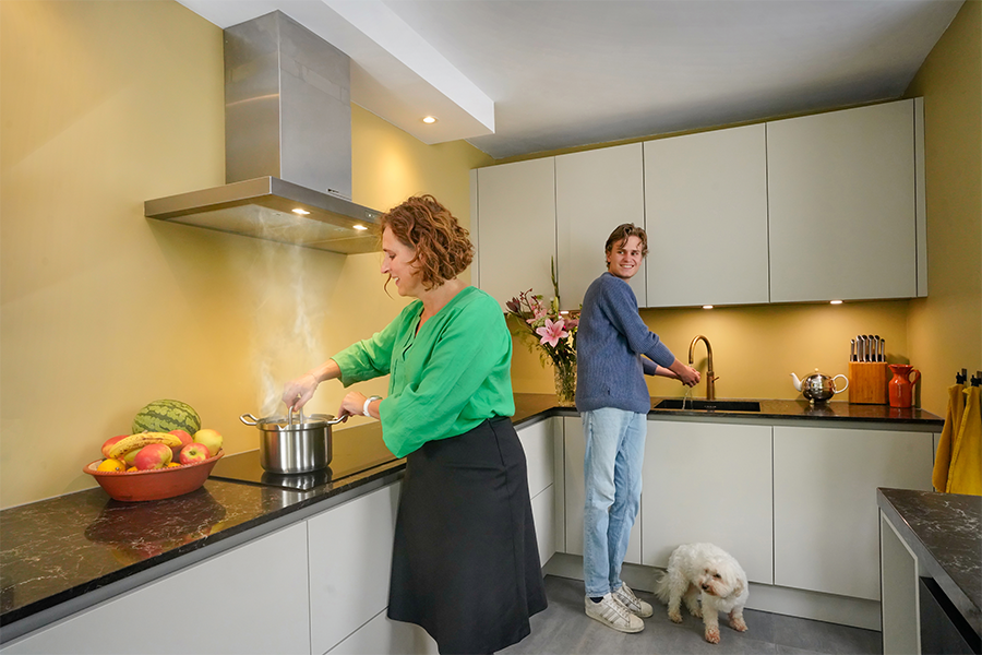 Vrouw kookt water in keuken